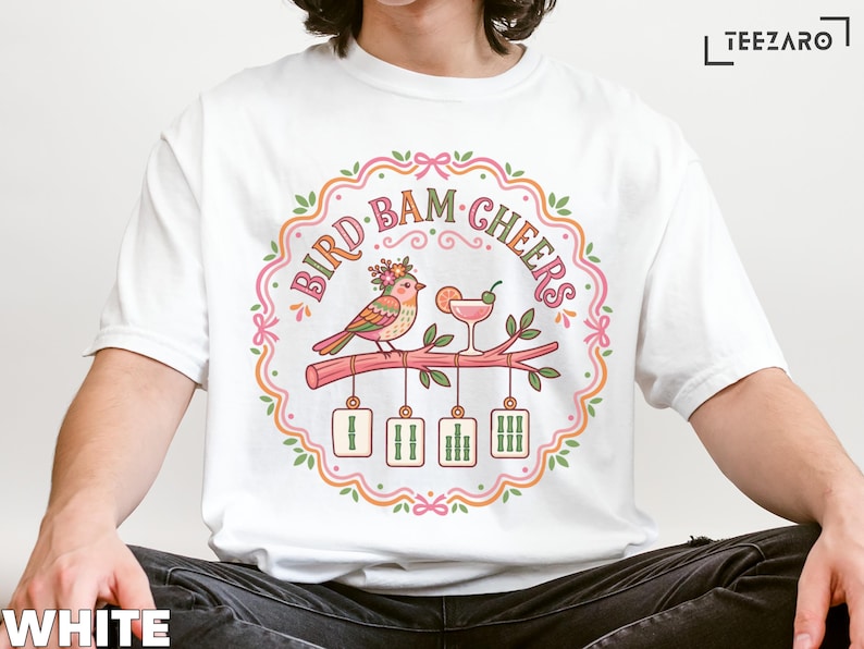White t-shirt with "Bird Bam Cheers" text and illustration of birds toasting.