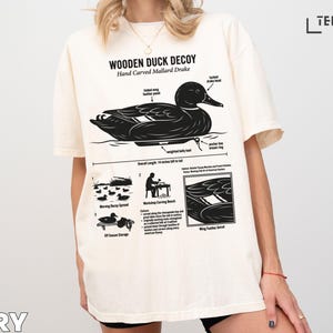 Wooden duck decoy illustration with text details on a t-shirt.