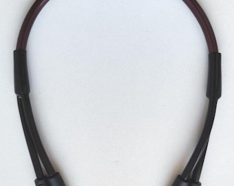 May include: A black and purple audio cable with gold-colored connectors. The cable has a curved, arch-like shape with black connectors at each end. The connectors have the text "TNR" printed on them.