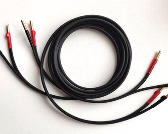 May include: Black speaker wire with gold-colored connectors and red insulation. The wire is coiled and has multiple individual leads extending from the coil. The connectors are designed to connect to audio equipment.
