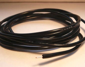 May include: Coiled black hook-up wire with visible text: "22 AWG. 600V." The wire has a single exposed end with a silver-colored wire tip. The wire is likely used for electrical projects or repairs.