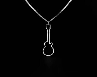 May include: A silver-colored necklace featuring a guitar pendant. The pendant is a minimalist outline of an acoustic guitar, suspended from a delicate chain. The background is solid black, highlighting the jewelry's design.