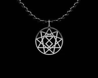 May include: Silver-colored pendant necklace featuring a geometric design within a circular frame. The pendant hangs from a delicate chain against a black background. The design includes stars and diamond shapes.