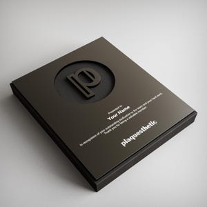May include: A black plaque with a silver letter "P" in a circle cutout. The plaque reads "Presented to Your Name In recognition of your outstanding dedication to the team and your hard work. Thank you for being a valuable member. plaquesthetic"