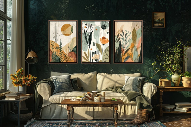 May include: Three abstract art prints with a nature theme. The prints feature a variety of colours, including green, brown, orange, and yellow. The prints are framed in a dark wood frame and are hanging on a dark green wall.