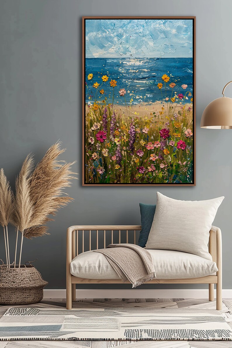 Puede incluir: Pintura vertical enmarcada que representa una escena costera. La mitad superior muestra un cielo azul texturizado y el oc&eacute;ano. La mitad inferior presenta una playa de arena con coloridas flores silvestres.