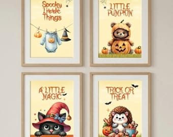 May include: Four framed wall art prints with light wood frames. The prints feature Halloween themes: a baby onesie with text Spooky Little Things, a bear in a pumpkin suit with text Little Pumpkin, a black cat in a witch hat with text A Little Magic, and a hedgehog with text Trick or Treat.