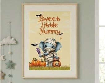 May include: A framed wall art print featuring a light blue elephant wrapped in white bandages like a mummy. The elephant holds a purple lollipop, stands in green grass with three orange pumpkins, and the text reads Sweet Little Mummy.