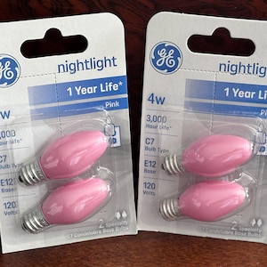 May include: Two packages of GE nightlight bulbs. Each package contains two pink C7 candelabra base bulbs. The packaging indicates a 4W rating, 3,000-hour life, and 120 volts.