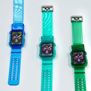 May include: Three clear Apple Watch bands in blue, teal, and green. Each band has a clear case with a black Apple Watch face displaying the time, date, and other information. The bands have a textured design.