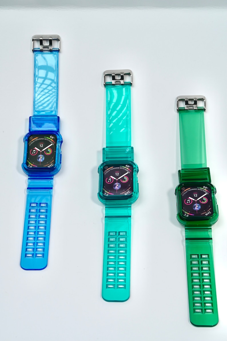 May include: Three clear Apple Watch bands in blue, teal, and green. Each band has a clear case with a black Apple Watch face displaying the time, date, and other information. The bands have a textured design.