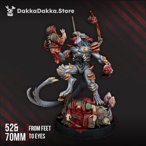 May include: A detailed miniature figure of a monstrous creature with a long tail, holding a severed head and weapon. The figure is gray, with orange and red accents. The base includes a figure and text that reads "52& 70mm". The store logo "DakkaDakka.Store" is in the top left.