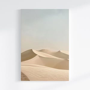 Könnte beinhalten: Ein Kunstdruck mit Sanddünen unter einem hellblauen Himmel. Die Dünen sind in einem warmen Beige gehalten, wobei Schatten Tiefe und Textur erzeugen. Das Kunstwerk vermittelt ein Gefühl von Ruhe und Weite, eine Wüstenlandschaft.