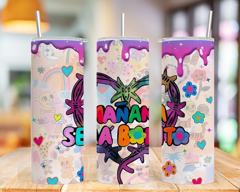 K&ouml;nnte beinhalten: Drei bunte Edelstahlbecher mit einem rosa, violetten und wei&szlig;en Design. Die Becher zeigen eine Vielzahl von Comic-artigen Bildern, darunter Herzen, Blumen, Regenb&ouml;gen und einen Totenkopf. Der Text "SE A BONITO" ist auf den Bechern sichtbar.
