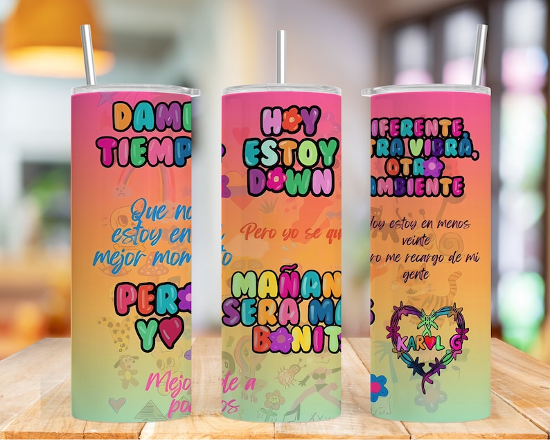 K&ouml;nnte beinhalten: Drei bunte Edelstahlbecher mit motivierenden Zitaten auf Spanisch. Die Becher haben einen Regenbogen-Verlaufshintergrund mit Comiczeichnungen und Herzen. Der Text auf den Bechern lautet "Dami Tiempo", "Hoy Estoy Down Pero Yo Se Que Manana Sera Mi Dia Bonito" und "Diferente Traivibra Otra Ambiente".