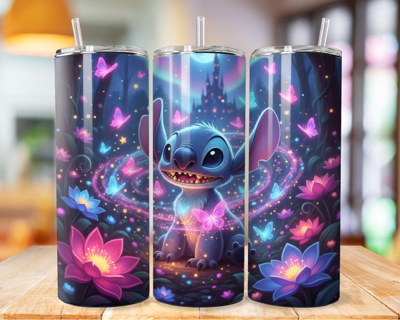 May include: A set of three stainless steel tumblers featuring a vibrant illustration of Stitch from Lilo & Stitch. The design includes a nighttime forest scene with a castle, butterflies, and glowing flowers in shades of blue, purple, and pink. Each tumbler has a clear straw.