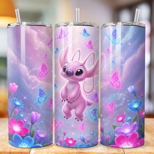 May include: A set of three stainless steel tumblers with a wraparound design featuring a pink cartoon character, butterflies, flowers, and a dreamy sky background. Each tumbler has a clear straw and lid.