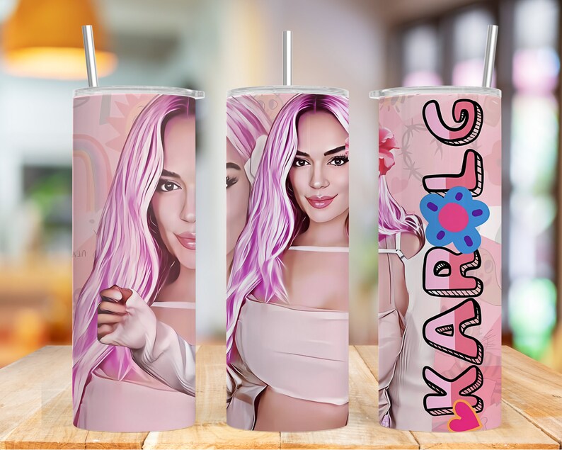 K&ouml;nnte beinhalten: Ein rosa-wei&szlig;er Becher mit einem Cartoon-Bild einer Frau mit rosa Haaren. Der Becher tr&auml;gt den Namen "KAROL" in rosa und wei&szlig;en Buchstaben mit einem rosa Herzen und einer blauen Blume.
