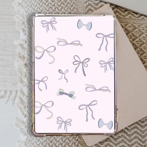 May include: A pink phone case featuring a pattern of pastel blue and purple bows. The bows are of various sizes and shapes.