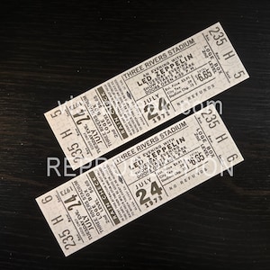 Puede incluir: Dos entradas de concierto vintage de Led Zeppelin del Three Rivers Stadium, con fecha del 24 de julio de 1973. Las entradas son blancas con texto negro, con el nombre de la banda y los detalles del evento. Las entradas son para asientos Loge Box.