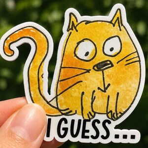 Peut inclure: Un autocollant de chat jaune au design fantaisiste. Le chat a de grands yeux, des moustaches et une longue queue incurvée. Le texte "I GUESS..." est imprimé en noir au bas de l'autocollant. L'autocollant est tenu par une personne.