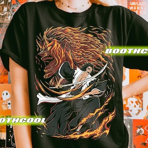 May include: Black t-shirt with an anime-style graphic. The design features a character with a sword, set against a fiery backdrop and a large, imposing figure. The text "BOOTHCOOL" is visible on the shirt.