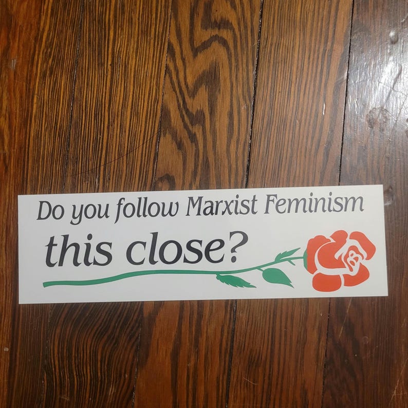 Op de afbeelding: Witte bumper sticker met de tekst "Do you follow Marxist Feminism this close?" en een rode roos met een groene steel en bladeren.
