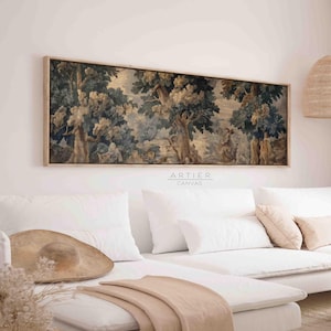May include: A white couch with a beige throw blanket and a brown hat on the seat. A framed tapestry with a forest scene hangs above the couch. The tapestry is in shades of blue, green, and brown. The text "ARTIER CANVAS" is printed below the tapestry.