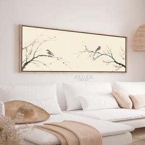 Puede incluir: Impresión en lienzo rectangular con un diseño de inspiración asiática. Dos pájaros posados en ramas con bayas rojas sobre un fondo crema. La obra de arte está enmarcada en madera clara. El texto "ARTIER CANVAS" está en la parte inferior.