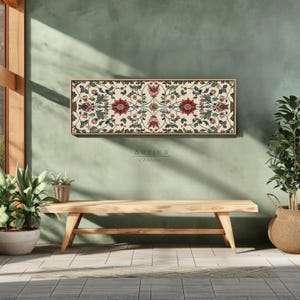 Puede incluir: Una impresi&oacute;n en lienzo rectangular con marco de madera, con un patr&oacute;n floral sim&eacute;trico de flores y hojas rojas, rosas y verdes sobre un fondo crema. La impresi&oacute;n cuelga sobre un banco de madera. El texto "ARTIER CANVAS" es visible.