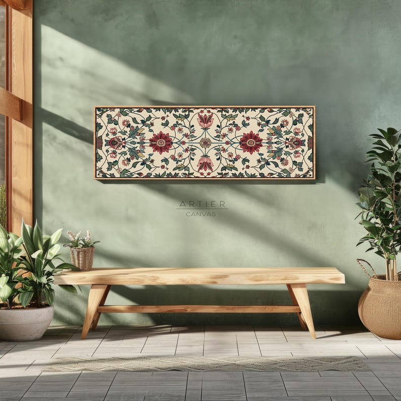 Puede incluir: Una impresi&oacute;n en lienzo rectangular con marco de madera, con un patr&oacute;n floral sim&eacute;trico de flores y hojas rojas, rosas y verdes sobre un fondo crema. La impresi&oacute;n cuelga sobre un banco de madera. El texto "ARTIER CANVAS" es visible.