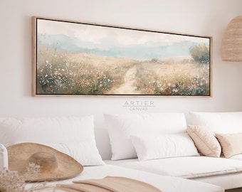 Puede incluir: Una impresión en lienzo rectangular que presenta un paisaje sereno con un camino que serpentea a través de un campo de flores silvestres. La obra de arte tiene una paleta de colores apagados de beige, verde y azul, y está enmarcada en madera clara. El texto "ARTIER CANVAS" está impreso en el lienzo.