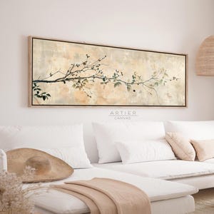 Puede incluir: Una impresión en lienzo rectangular que presenta una rama con hojas y bayas en tonos verdes y negros sobre un fondo beige y crema. La obra de arte está enmarcada en madera clara. El texto "ARTIER CANVAS" es visible.