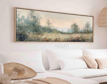 Puede incluir: Pintura de paisaje rectangular en un marco de madera clara. La obra representa un campo con árboles y una paleta de colores suaves y apagados de verdes, azules y beige. El texto "ARTIER CANVAS" es visible en la parte inferior de la pintura.