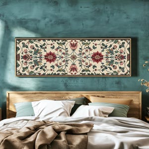 Puede incluir: Arte floral rectangular sobre lienzo con fondo crema y un patr&oacute;n detallado de flores rojas, verdes y rosas. La obra de arte est&aacute; enmarcada en un marco de madera oscuro y fino y cuelga sobre una cama. El texto "ARTIER CANVAS" es visible.