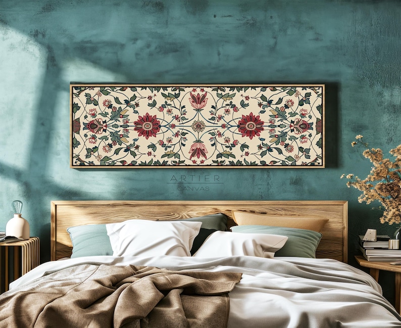 Puede incluir: Arte floral rectangular sobre lienzo con fondo crema y un patr&oacute;n detallado de flores rojas, verdes y rosas. La obra de arte est&aacute; enmarcada en un marco de madera oscuro y fino y cuelga sobre una cama. El texto "ARTIER CANVAS" es visible.