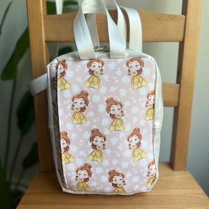 May include: A white faux leather backpack with a pink and white print of Belle from Beauty and the Beast. The backpack has a zipper closure and adjustable straps.