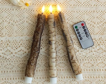 May include: Three battery-operated LED candles with a realistic bark and birch wood design. The candles have flickering amber lights and white bases. A remote control is included for operation.