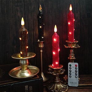 以下が含まれることがあります： 茶色、黒、赤など、さまざまな色の4つのLEDキャンドルが、装飾的な真鍮の燭台に飾られています。キャンドルはちらつき効果があり、小さなライトで飾られています。リモコンが表示され、キャンドルの機能を制御できます。