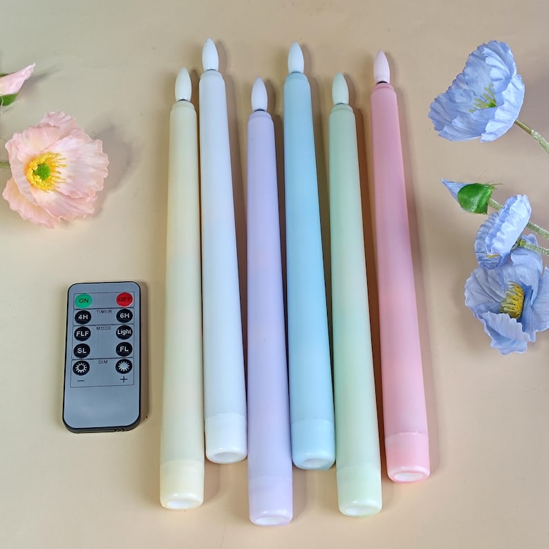 May include: A set of pastel-coloured LED taper candles with a remote control. The candles are in cream, white, lavender, blue, green, and pink. The remote control has buttons for on/off, timer, and light mode.