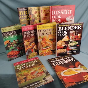 Könnte beinhalten: Eine Sammlung von Vintage-Kochbüchern von "Better Homes & Gardens", darunter "Meals in Minutes" und "Blender Cook Book". Die Bücher haben farbenfrohe Umschläge mit Lebensmittelillustrationen, die sich auf Hausmannskost und Rezepte konzentrieren.