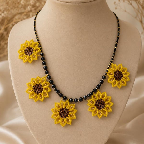 May include: A beaded necklace featuring a string of small, round, glossy black beads interspersed with five sunflower-shaped charms. Each sunflower charm is crafted from tiny yellow and brown beads, creating a detailed floral pattern.