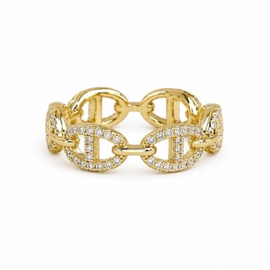 May include: A gold-toned ring featuring a continuous chain-link design. Each oval link is embellished with small, clear, sparkling stones set along the outer surface, creating a uniform, textured, and reflective metallic appearance throughout.