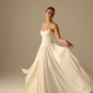 Satin wedding dress with strapless bodice, high slit skirt and detachable sleeves