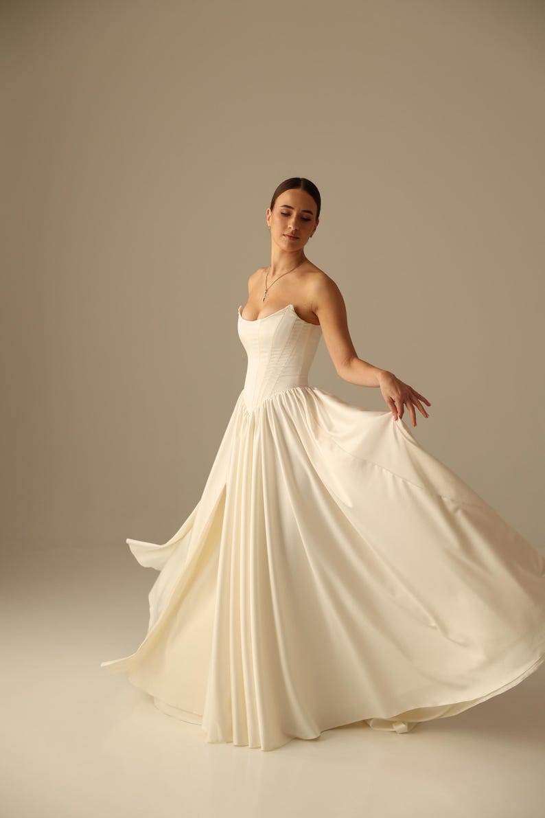 Satin wedding dress with strapless bodice, high slit skirt and detachable sleeves