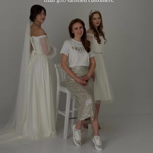 May include: Three ivory wedding dresses and a bride-to-be in a sparkly silver skirt and white t-shirt.  The t-shirt has the word 'FRIDAY' printed on it. The models are posing against a light gray background. Text on the image reads: 'We are a young store on Etsy. However, we have been creating wedding dresses for more than five years, and we already have more than 400 satisfied customers.' and 'We will be happy to create a unique dress for you for your special day!'