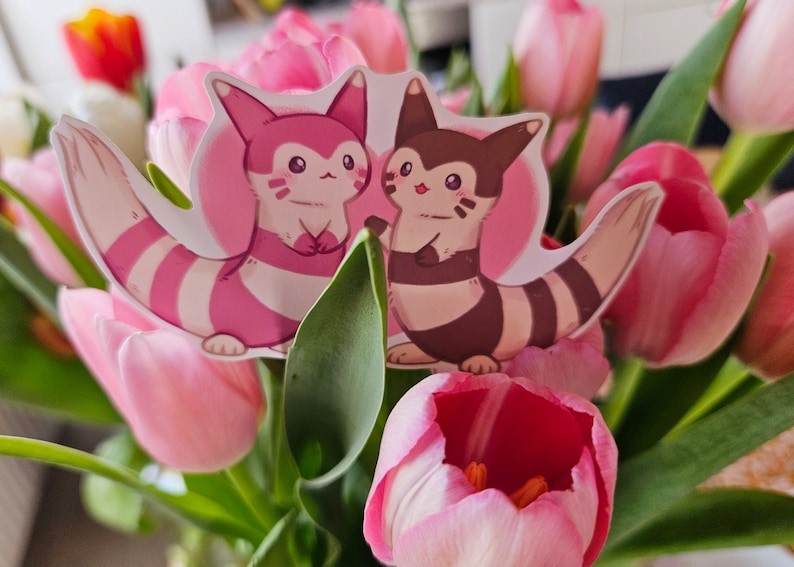 May include: Two pink and brown cartoon animal stickers with white stripes on a bouquet of pink tulips.