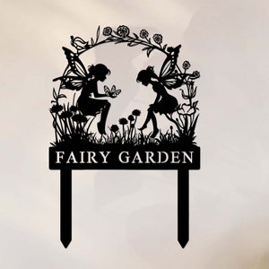 May include: Black metal silhouette of two fairies with wings, sitting in a garden with flowers and a butterfly. The sign reads "FAIRY GARDEN".