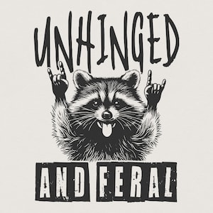 May include: A monochrome illustration featuring a raccoon with its tongue sticking out, throwing a rock and roll hand sign. The words "UNHINGED" and "AND FERAL" are printed above and below the raccoon in a bold, distressed font.