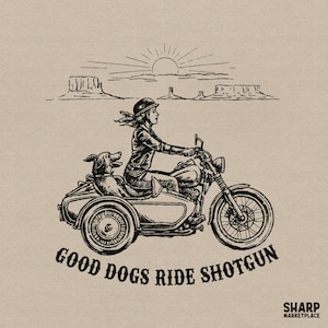 May include: A black ink illustration on a beige background depicting a person wearing a helmet riding a motorcycle with a sidecar containing a dog. The scene includes a desert landscape with mesas and a sun. Text reads: GOOD DOGS RIDE SHOTGUN.